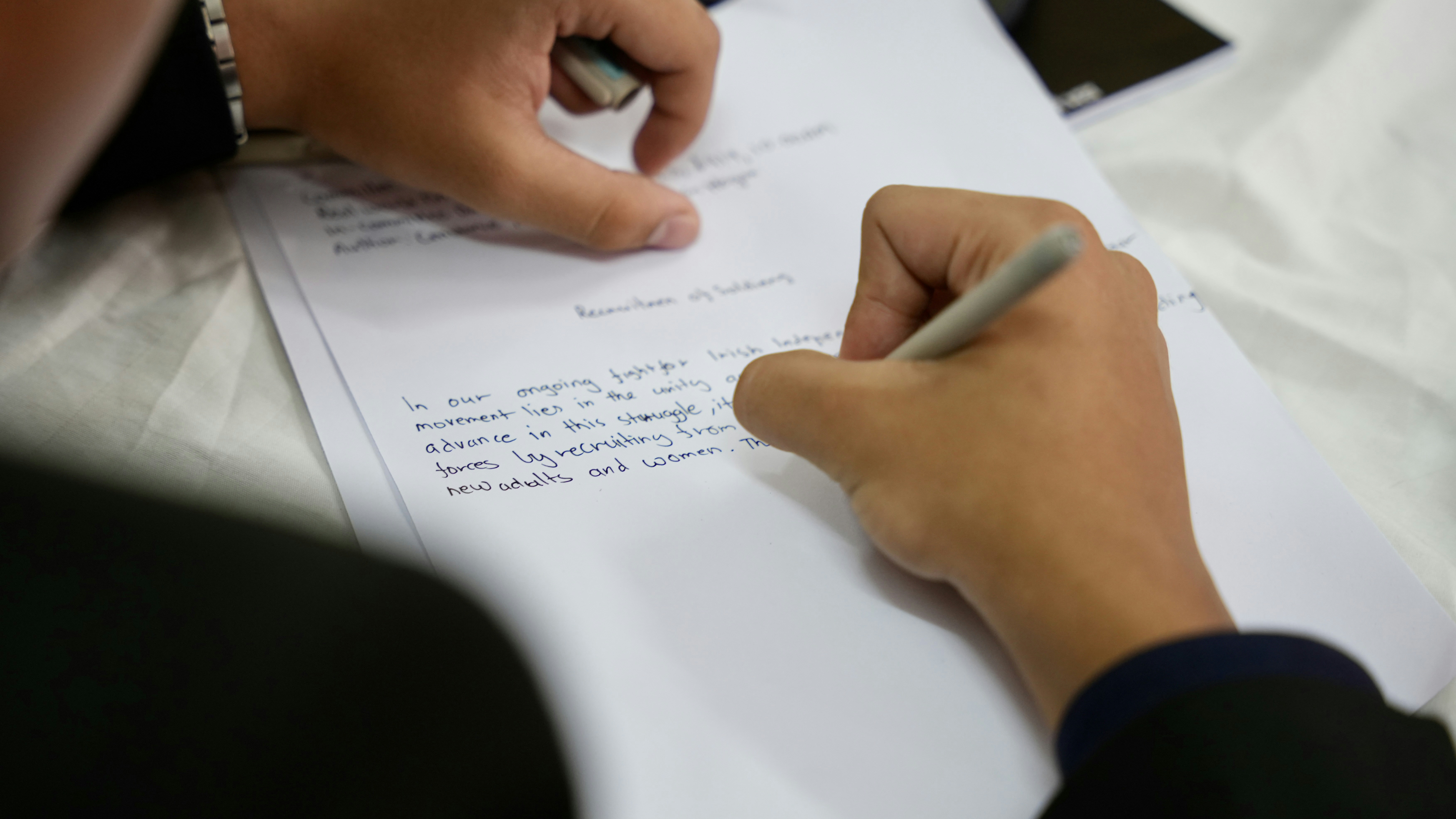 A Person Writing with a Pen Over the Shoulder Close Up